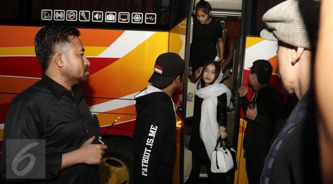 Sejumlah member grup idola JKT48 turun dari bus saat melayat ke kediaman Inao Jiro di Kota Tangerang Selatan, Rabu (22/3). Member sekaligus leader JKT48, Melody juga tampak hadir diantara rombongan. (Liputan6.com/Herman Zakharia)