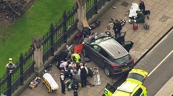 Tim paramedis menangani korban serangan teror di dekat gedung Parlemen Inggris, London, Rabu (22/3). Setelah menabrak pejalan kaki, pelaku melaju ke depan gedung parlemen, kemudian keluar dan menikam salah satu polisi yang berjaga. (ITN via AP)