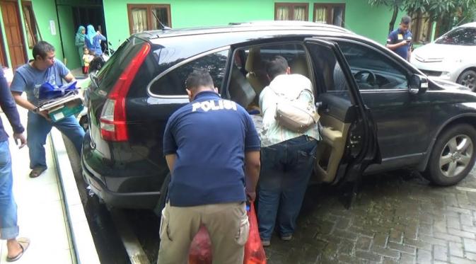 Keluarga dan polisi mengambil barang-barang Akseyna Ahad Dori dari kamar kosnya. (Ady Anugrahadi/Liputan6.com)