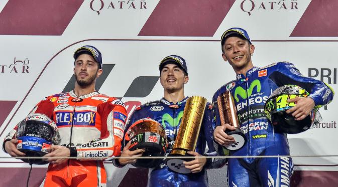 (Ki-ka) Pembalap Ducati, Andrea Dovizioso serta dua pembalap Movistar Yamaha, Maverick Vinales dan Valentino Rossi berdiri di atas podium MotoGP Qatar di Sirkuit Losail, Minggu (26/3). Vinales keluar sebagai pemenang MotoGP Qatar. (AP Photo/Rafa Marrodan)