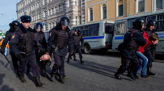 Polisi Rusia menangkap pengunjuk rasa dalam protes anti-korupsi di pusat kota Moskow, Minggu (26/3). Alasan penahanan adalah aksi demo disebut ilegal karena dilakukan tanpa mengajukan perizinan resmi kepada otoritas keamanan Rusia. (Alexander UTKIN/AFP)