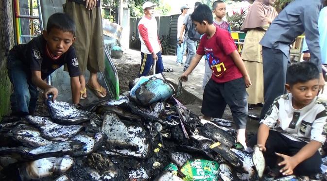 Siswa memunguti sisa buku sekaligus memusnahkannya akibat sekolah mereka terbakar (Zainul Arifin/Liputan6.com)