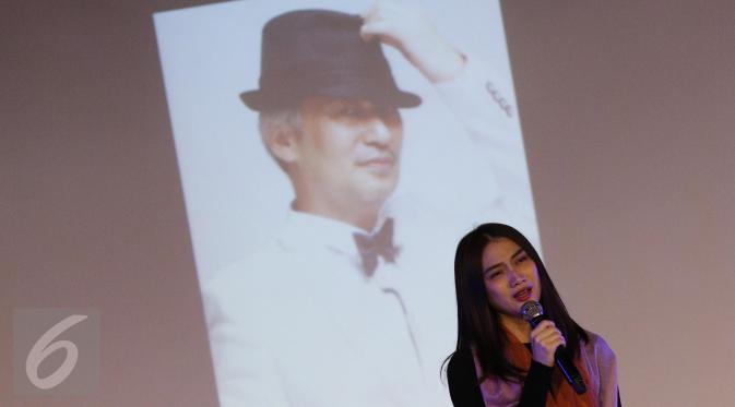 Kapten grup idol JKT 48, Melody dengan latar belakang foto Inao Jiro saat pembukaan untuk mengheningkan cipta dan doa bersama di JKT48 Theater, Jakarta, Senin (27/03). (Liputan6.com/Herman Zakharia)