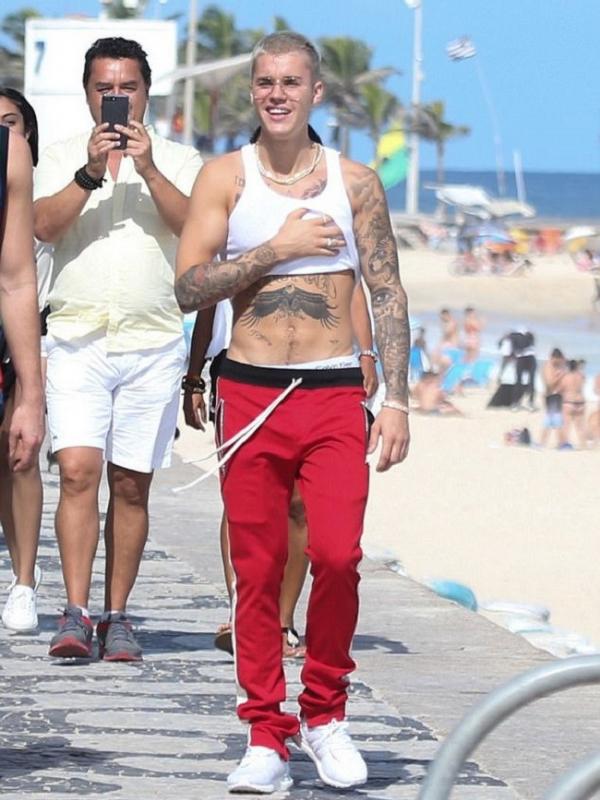 Justin Bieber dikerubungi penggemar saat berada di sebuah pantai di Brazil, Rabu (29/3/2017). (via. Dailymail)