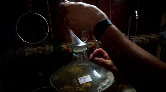 Pembuat wine menutup kendi anggur racikannya dengan kondom, Havana, Kuba, Kamis (30/3). Estevez mengisi kendi tersebut dengan campuran anggur, jahe dan kembang sepatu. (AP Photo)