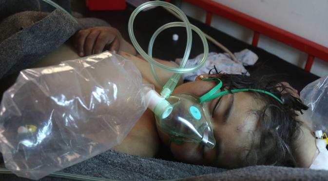Seorang balita mendapatkan perawatan setelah diduga terkena serangan gas beracun di sebuah kota yang dikuasai pemberontak di Suriah, Selasa (4/4). Puluhan orang dikabarkan mengidap gangguan pernapasan akibat serangan ini. (Mohamed al-Bakour/AFP)