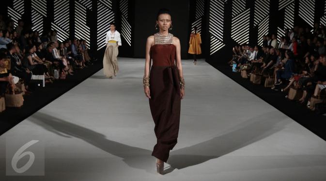 Model membawakan busana rancangan teranyar Andreas Odang pada malam pembukaan Senayan City Fashion Nation ke-11, Kamis (6/4). Sebanyak 15 busana wanita hadir dalam balutan warna-warna hangat, gelap, dan cenderung muted. (Liputan6.com/Herman Zakharia)