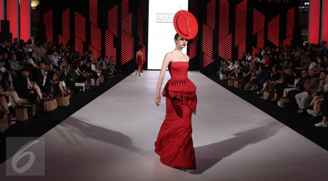 Seorang model membawakan busana rancangan teranyar Yogie Pratama pada malam pembukaan Senayan City Fashion Nation ke-11, Kamis (6/4). Yogie menampilkan 'Scarlet', sebuah koleksi deluxe ready to wear yang serba merah. (Liputan6.com/Herman Zakharia)