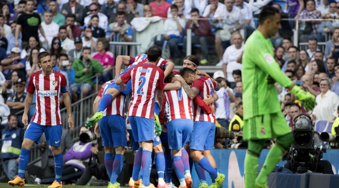 Para pemain Atletico Madrid merayakan gol Antoine Griezmann ke gawang Real Madrid, pada laga lanjutan La Liga 2016-2017, di Stadion Santiago Bernabeu, Sabtu (8/4/2017) malam WIB. Duel kedua tim berakhir imbang 1-1.  (AFP/Curto De La Torre)