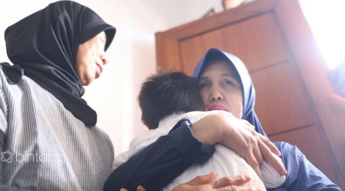 Anak Renita Sukardi tak kuasa menahan haru melihat ibunya terbujur kaku. (Nurwahyunan/Bintang.com)