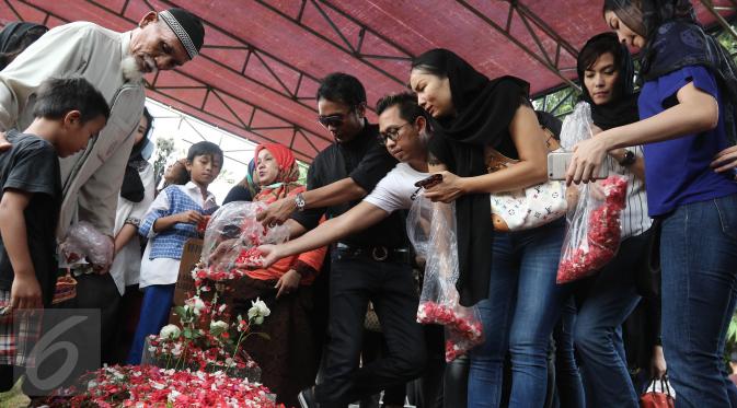 Penaburan bunga di makam Renita Sukardi di TPU Menteng Pulo, Jakarta, Senin (10/4). Renita Sukardi menghembuskan napas terakhirnya di usia 37 tahun. Ia meninggalkan seorang suami dan anak laki-laki. (Liputan6.com/Herman Zakharia)