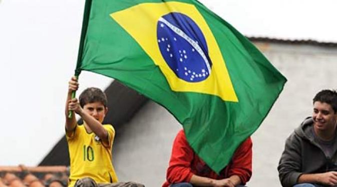 Seorang bocah suporter Brasil antusias menyaksikan Kaka dkk berlatih sambil mengibarkan bendera negara, sebagai bentuk dukungan untuk PD 2010. AFP PHOTO/VANDERLEI ALMEIDA