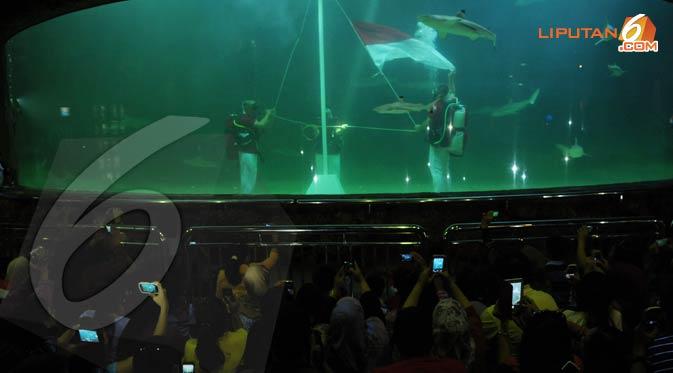 Para pengunjung tempat rekreasi Seaworld Ancol Jakarta Utara sedang menyaksikan detik - detik pengibaran bendera merah putih di dalam akuarium hiu. (Liputan6.com/Andrian M Tunay)  