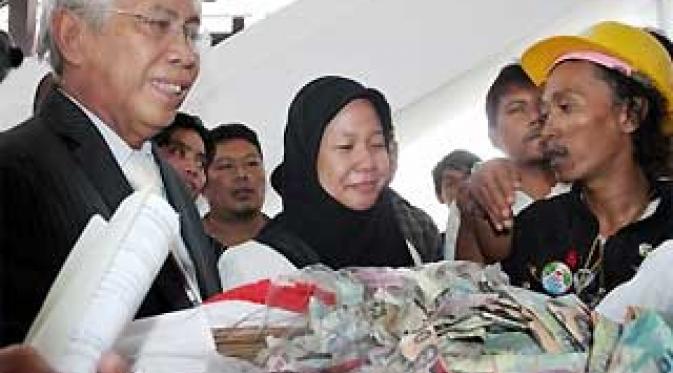 Prita Mulyasari (tengah), didampingi kuasa hukum OC Kaligis (kiri), menerima sumbangan uang yang berhasil dikumpulkan oleh anak jalanan dan komunitas anak langit, di PN Tangerang, Banten. (Antara)