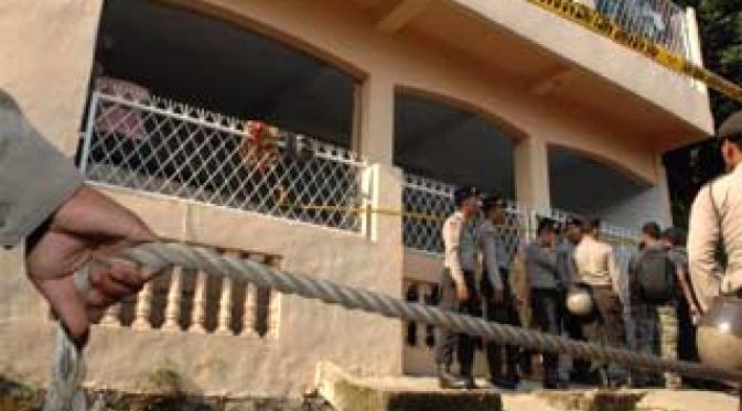 Anggota kepolisian berjaga di depan rumah kos tersangka terorisme, Syaifudin Zuhri dan Mohamad Syahrir di Ciputat, Tangerang, Jumat (9/10). Dua tersangka teroris tewas dalam baku tembak.(Antara)