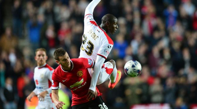 Bek Manchester United, Marnick Vermijl (kiri), menahan pemain depan Milton Keynes Dons, Benik Afobe, saat berlaga di ajang Piala Liga Inggris, di Stadion MK, London, (27/8/2014). (AFP PHOTO/Carl Court)