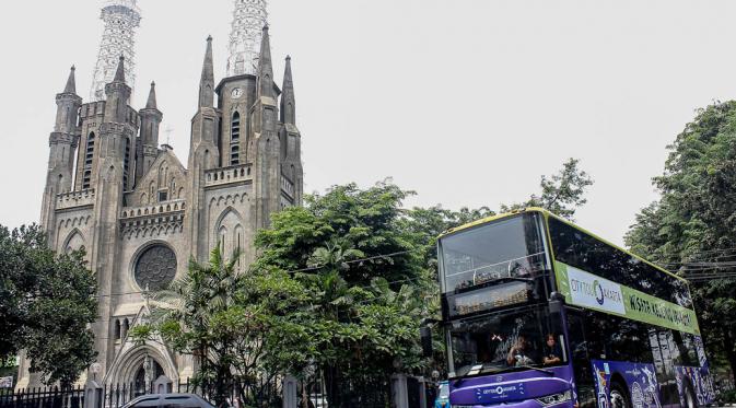 Bus tingkat wisata jurusan Pasar Baru-Bundaran HI melintas di Kawasan Gereja Katedral, Jakarta, (6/10/14). (Liputan6.com/ Faizal Fanani)