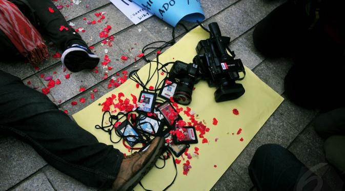 Sejumlah wartawan mengumpulkan ID Card, kamera, dan alat perekam saat berunjuk rasa di Bundaran HI, Jakarta, Jumat (14/11/2014). (Liputan6.com/Johan Tallo)