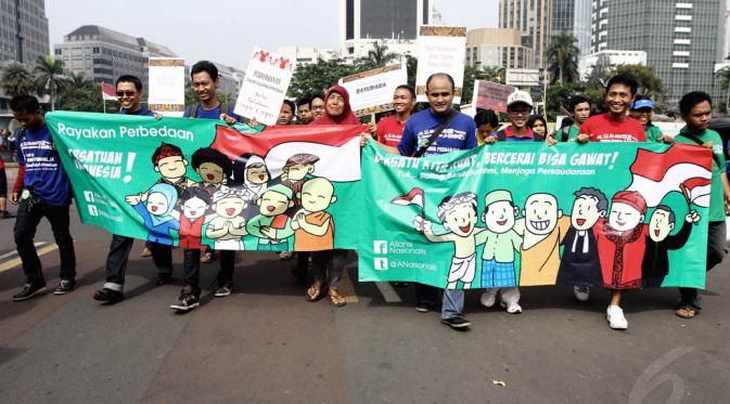 Peserta longmarch tampak membentangkan spanduk kerukunan umat beragama dalam acara perayaan Hari Toleransi Internasional, Jakarta, Minggu (16/11/2014). (Liputan6.com/Faizal Fanani)