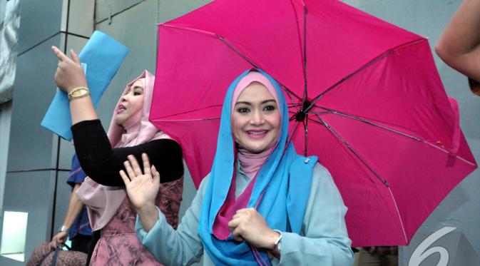 Wajah bahagia terpancar dari Eddies Adelia yang mengenakan  kerudung biru saat resmi keluar dari Rumah Tahanan Pondok Bambu, Jakarta Timur, Jumat (5/12/2014). (Liputan6.com/Panji Diksana)