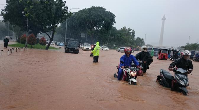 Sejumlah kendaraan nekat melintasi jalan di depan istana Negara yang terendam banjir, Jakarta, Senin (9/2/2015).(Antara Foto/Fanny Octavianus)