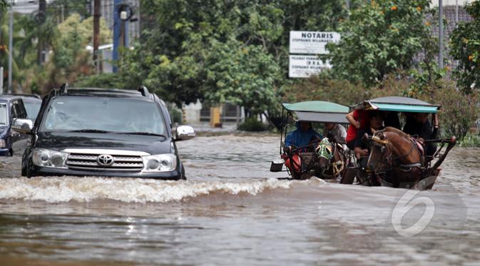 Hujan yang mengguyur Jakarta sejak Minggu (8/2) lalu, mengakibatkan tingginya genangan air di kawasan Kelapa Gading. Tampak mobil dan delman berusaha menerobos banjir, Jakarta, Selasa (10/2/2015). (Liputan6.com/Faizal Fanani)