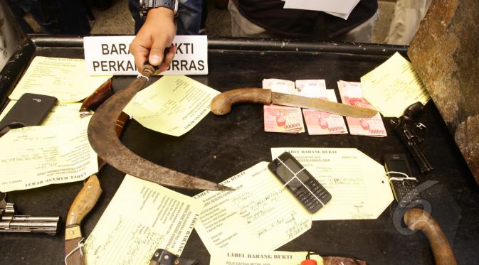 Barang bukti dua pistol mainan, empat telepon seluler, empat golok, sebilah celurit dan uang tunai Rp 2,2 juta ditunjukkan pihak kepolisian, Jakarta, Selasa (17/3/2015).(Liputan6.com/Johan Tallo)