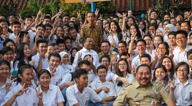 Presiden Joko Widodo, Mendikbud Anies Baswedan dan Gubernur DKI Basuki Tjahaja Purnama berfoto bersama para siswa saat meninjau pelaksanaan Ujian Nasional (UN) di SMA Negeri 2 Jakarta, Selasa (14/4/2015). (Liputan6.com/Faizal Fanani)
