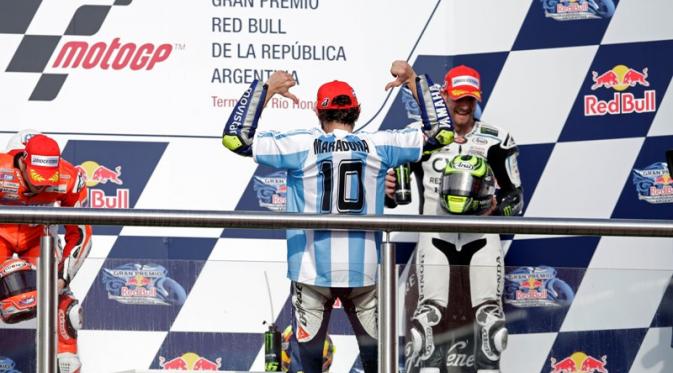 Saat menaiki podium juara, Valentino Rossi memakai jersey timnas Argentina dengan nama Diego Maradona yang merupakan legenda tim Tango. (AP Photo/Natacha Pisarenko)