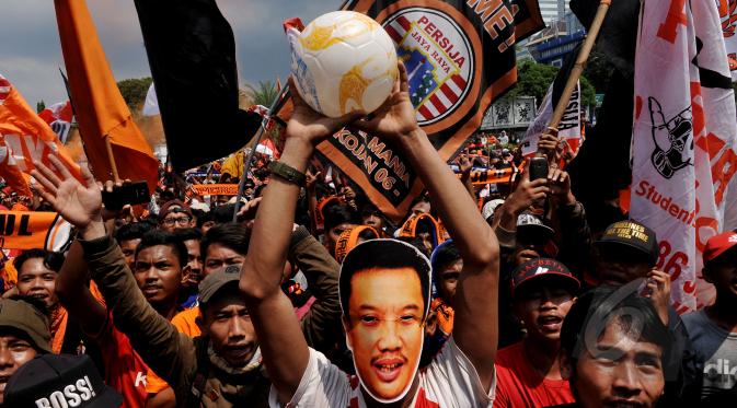 Puluhan ribu Jakmania (suporter tim Persija) menggelar aksi di depan Istana Negara, Jakarta, Selasa (5/5/2015). Dalam aksinya, salah satu anggota Jakmania menggunakan topeng wajah Menpora Imam Nahrawi.  (Liputan6.com/Johan Tallo)