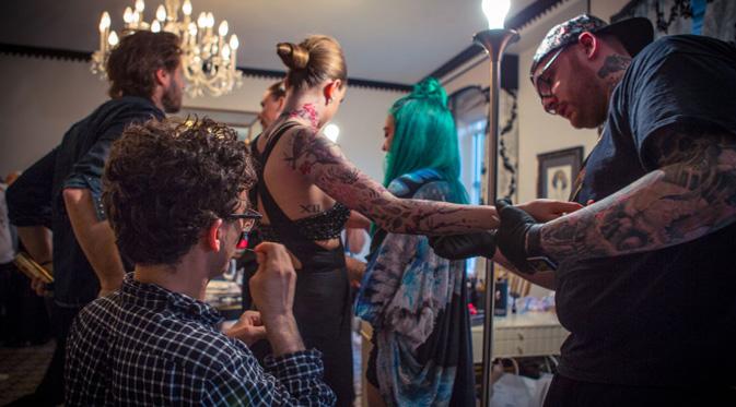 Cara Delevinge saat proses tubuhnya dilukis tato. (foto: mtv.com)