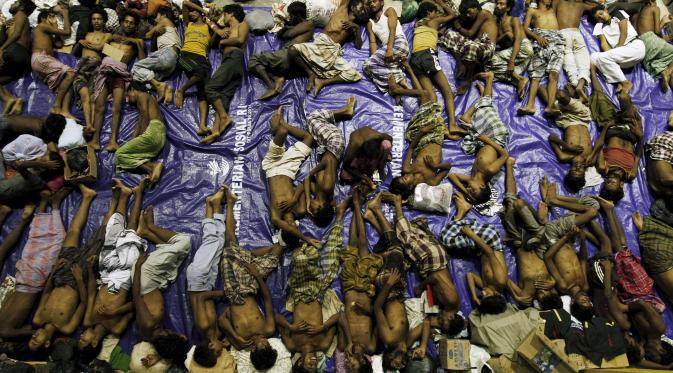 Dengan beralaskan terpal para pengungsi tidur di tempat penampungan, Lhoksukon, Aceh, Senin (11/5/2015). Sekitar 500 migran terdampar di pantai Aceh setelah terapung-apung di laut selama sebulan karena kehabisan bahan bakar. (REUTERS/Roni Bintang)