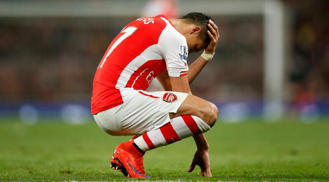 Penyerang Arsenal, Alexis Sanchez terlihat sedih usai timnya dikalahkan saat Laga Liga Premier Inggris di Emirates Stadium, Selasa (12/5/2015). Swansea City menang 1-0 atas Arsenal. (Reuters/Andrew Couldridge)