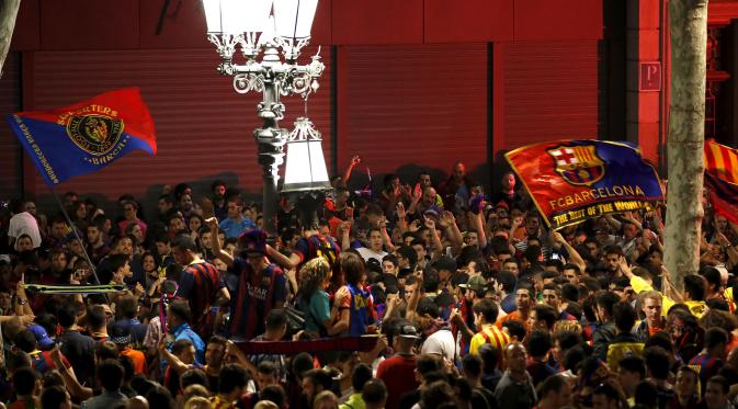 Pendukung Barcelona mengibarkan bendera tim kesayangannya pada saat merayakan keberhasilan Barcelona menjuarai La Liga Spanyol di Barcelona (18/5/2015). Barcelona juara setelah mengalahkan Atletico Madrid 1-0. (REUTERS/Gustau Nacarino)