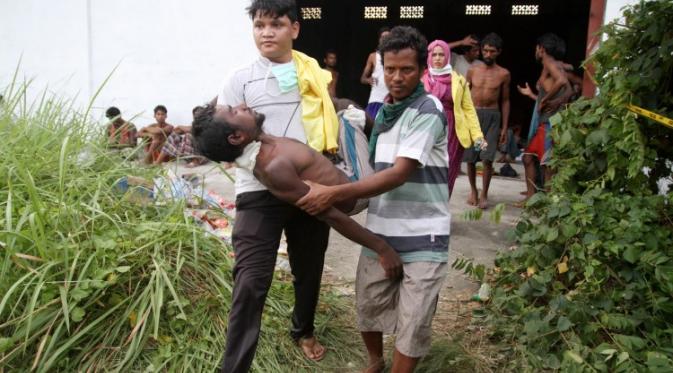 Suku Rohingya yang pingsan sedang digotong oleh relawan