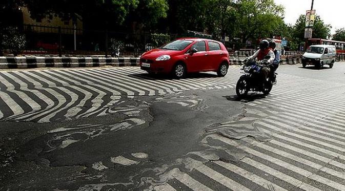 Permukaan aspal di Delhi, India, mulai meleleh akibat terkena paparan udara yang sangat panas.
