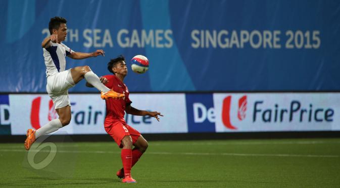 Bek timnas Filipina U-23, F J Daviz Arboleda (kiri) melompat berebut bola dengan gelandang Singapura, Adam Swandi di laga grup A Sea Games 2015 di Stadion Jalan Besar, Singapura, Senin (1/6/2015). Singapura unggul 1-0. (Liputan 6.com/Helmi Fithriansyah)