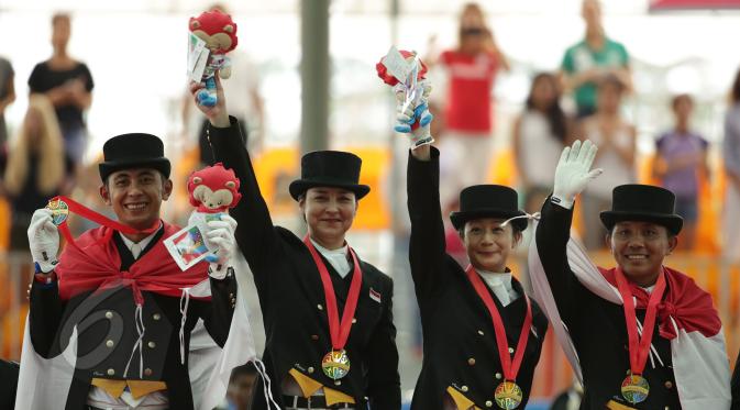 Tim berkuda Indonesia meraih medali emas Sea Games 2015 nomor nomor tunggang serasi tim yang dihelat di Singapore Turf Club Riding Centre, Sabtu (6/6/2015). Tampak, tim berkuda Indonesia berfoto usai pengalungan medali. (Liputan6.com/Helmi Fithriansyah)