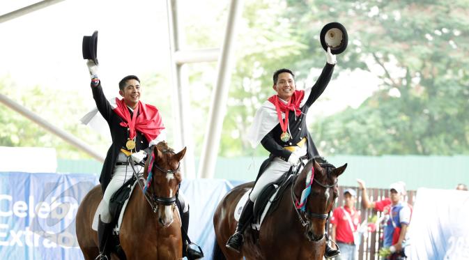 Atlet berkuda, Ferry Wahyu (kiri) dan Alfaro Menayang melakukan selebrasi kemenangan di Singapore Turf Club Riding Centre, Sabtu (6/6/2015). Tim berkuda Indonesia meraih emas di nomor tunggang serasi tim Sea Games 2015. (Liputan6.com/Helmi Fithriansyah)