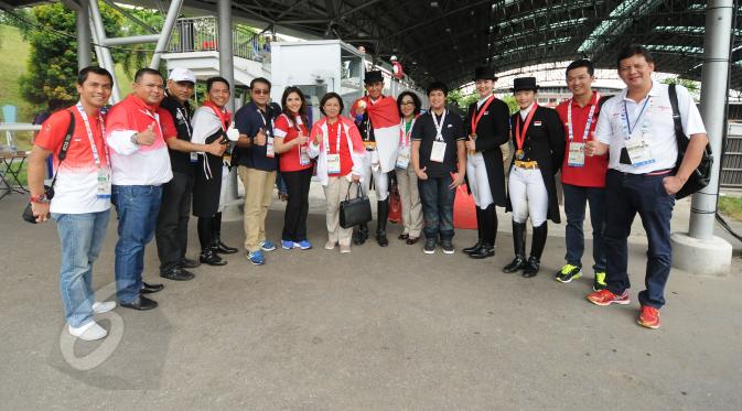 Tim berkuda Indonesia berfoto bersama dengan Ketua KOI, Rita Subowo (ketujuh kiri) usai meraih emas di nomor tunggang serasi tim Sea Games 2015 yang dihelat di Singapore Turf Club Riding Centre, Sabtu (6/6/2015). (Liputan6.com/Helmi Fithriansyah)