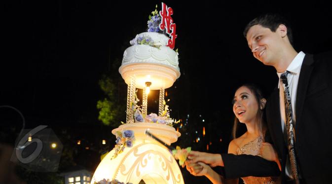 Nadia Vega bersama tunangannya Sultan Yaar Jorik Jacob Dozy memotong kue pesta di Kebun Raya Bogor, Jawa Barat, Sabtu (6/6/2015). Nadia menggelar acara lamarannya dengan konsep garden party. (Liputan6.com/Panji Diksana)