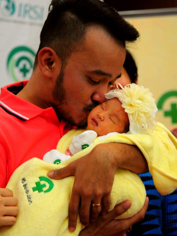Ruben Onsu mencium anak pertamanya, RS Bunda, Jakarta, Minggu (7/6/2015). Ruben memberi nama anak pertamanya Thalia Putri Onsu (Liputan6.com/Faisal R Syam)
