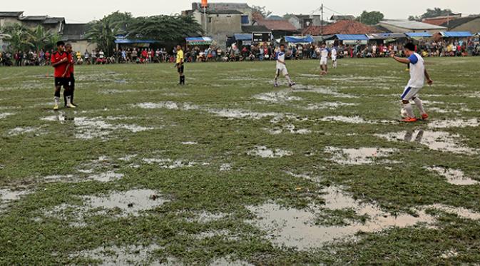 Suasana lapangan sepak bola Latus, Ciputat Tangerang Selatan yang tergenang air saat sepak bola tarkam dilangsungkan. (Bola.com/Peksi Cahyo)