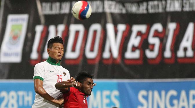 Bek tengah Indonesia U-23 Agung Prasetyo berduel dengan pemain Singapura U-23 (Bola.com/ Arief Bagus)