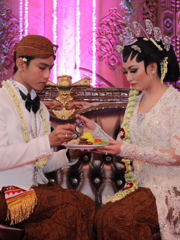 Selvi Ananda dan Gibran Rakabuming sedang melakukan prosesi dulangan. (Galih W. Satria/Bintang.com)