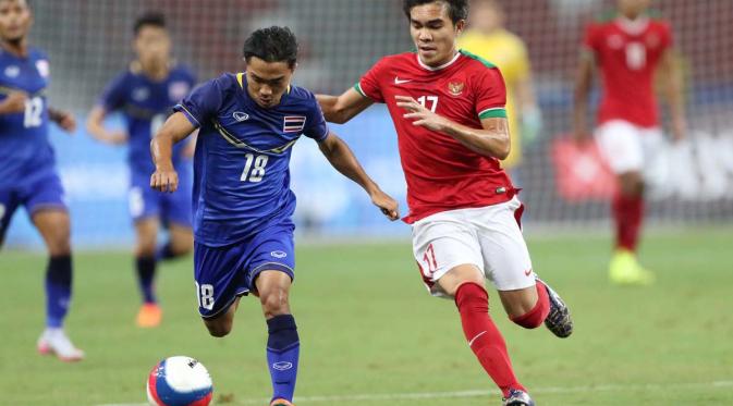 Pemain Indonesia U-23, Paulo Oktavianus Sitanggang, saat berebut bola dengan Chanatip Songkrasin di SEA Games 2015. (Bola.com/Arief Bagus)