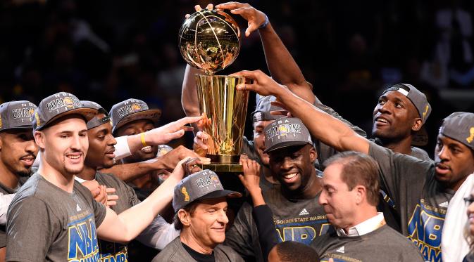 Para Pemain Golden State Warriors memegang trofi usai mengalahkan Cleveland Cavaliers di pertandingan ke enam final NBA di Quicken Loans Arena,  Cleveland, (17/6/2015). Warriors unggul atas Cavaliers 4-2 dalam format best of seven. (Reuters/Bob Donnan)