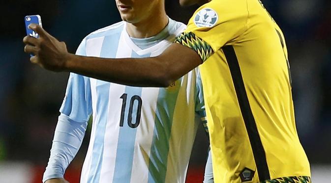 Lionel Messi diajak selfie pemain Jamaika DeShorn Brown di Estadio Sausalito in Vina del Mar, Chile (REUTERS/Ivan Alvarado)