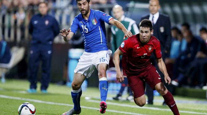 BEREBUT - Pemain Italia Marco Benassi (kiri) berebut bola dengan Raphael Guerreiro (kanan). (Reuters / Carl Recine)