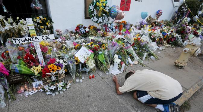 Raymond Smith, seorang jemaat berdoa di depan karangan bunga di Gereja Emanuel, Charleston, Amerika Serikat, Minggu (21/6/2015). Gereja tersebut dibuka kembali untuk jemaat yang berkabung usai penembakan yang menewaskan 9 orang. (REUTERS/Brian Snyder)